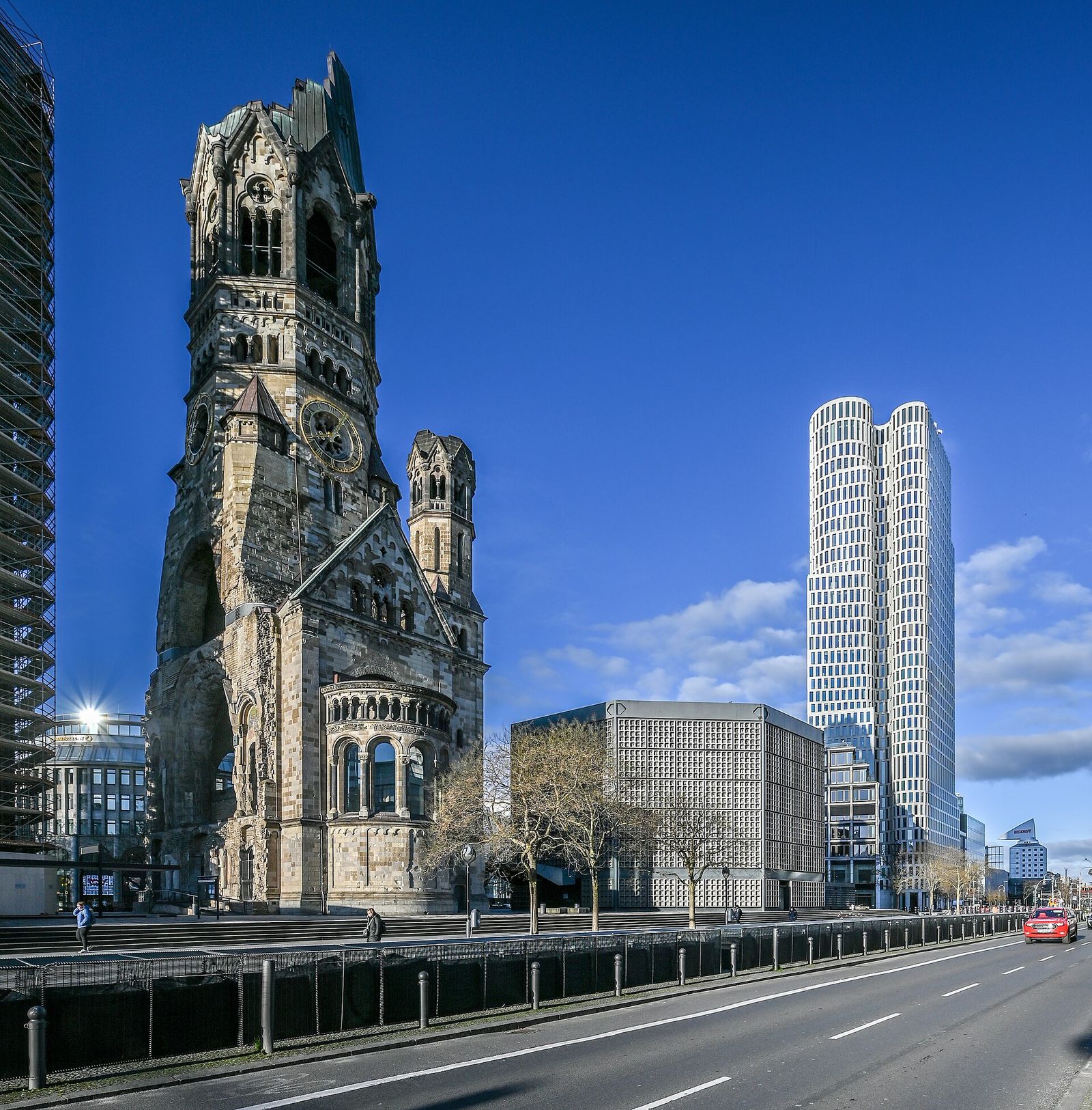 Die Turmruine der Kaiser-Wilhelm-Gedächtniskirche am Breitscheidplatz, daneben der achteckige Kirchenneubau von Egon Eiermann und ein modernes Hochhaus