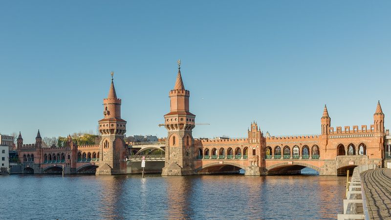 Die Oberbaumbrücke mit ihren zwei Backsteintürmen und Bogengängen über der Spree in warmem Licht