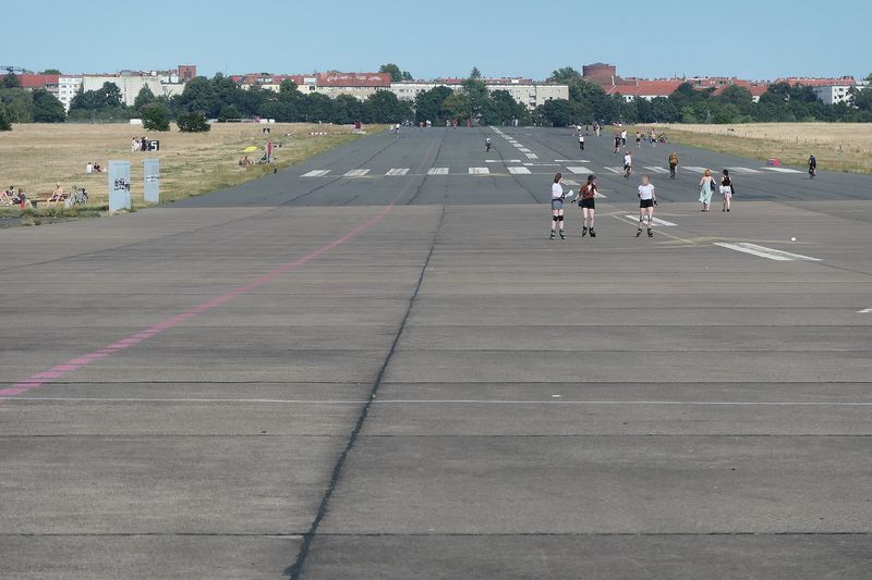 Die ehemalige Start- und Landebahn auf dem Tempelhofer Feld mit Skaterinnen, Radfahrern und Spaziergängern an einem Sommertag